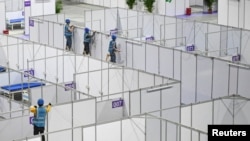 FILE - Workers set up equipment inside Pazhou International Convention Exhibition Center to convert it into a makeshift hospital, in Guangzhou, Guangdong province, China, April 10, 2022. 