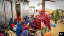 FILE - Somalis who fled drought-stricken areas receive food donations from city residents after arriving at a makeshift camp for the displaced on the outskirts of Mogadishu, Somalia, June 30, 2022. 