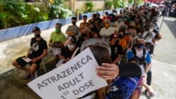 Residents wait to be inoculated with COVID-19 vaccines at a school during the first day of a nationwide three-day vaccination drive in Quezon city, Philippines on Monday, Nov. 29, 2021. (AP Photo/Aaron Favila)