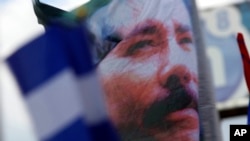 ARCHIVO - Una pancarta adornada con una imagen del presidente de Nicaragua, Daniel Ortega, es agitada por un partidario en Managua, Nicaragua, el 30 de abril de 2018.