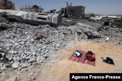 FILE - Palestinian Muslim worshippers pray near the rubble of a destroyed mosque in Beit Lahia, in the northern Gaza Strip, on May 27, 2021, following an 11-day conflict between Israel and Hamas.