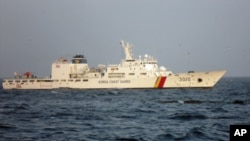 A Chinese trawler (C) capsizes after colliding with a South Korean Coast Guard boat in the waters off Gunsan, south of Seoul December 18, 2010.