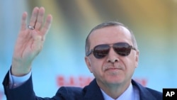 Turkey's President Recep Tayyip Erdogan waves to supporters as he attends an opening ceremony for a rail commute line in Ankara, Turkey, April 12, 2018.