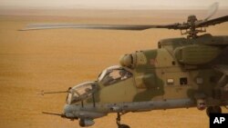 FILE - A Russian military helicopter flies over a desert in Deir el-Zour province, Syria, Sept. 15, 2017.