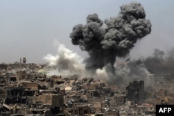 FILE - A picture taken on July 9, 2017, shows smoke billowing following an airstrike by US-led international coalition forces targeting Islamic State (IS) group in Mosul.