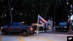 Partidarios del expresidente Donald Trump pasan frente a su propiedad en Mar-a-Lago el lunes 8 de agosto de 2022 en Palm Beach, Florida. (Foto AP/Terry Renna)