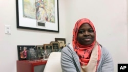 FILE - Fartun Abdi, a 25-year-old Somalian sits at work in Nashville, Tennessee, Dec. 17, 2019. 