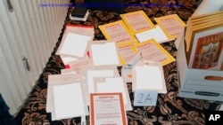 This image from a court filing by the Department of Justice on Aug. 30, 2022, and redacted by in part by the FBI, shows a photo of documents seized during the Aug. 8 search by the FBI of former President Donald Trump's Mar-a-Lago estate in Florida.