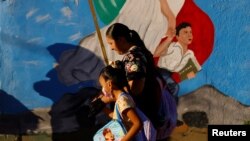 FILE - An elementary school student wearing a protective mask returns to full-time face-to-face classes for the first time, after having online and staggered classes, as COVID-19 outbreak continues, in Ciudad Juarez, Mexico, Aug. 29, 2022.