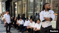 Kitchen staff wait outside a restaurant during a power outage in Toronto, Canada, Aug. 11, 2022.