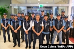This picture released Aug. 29, 2022, on the official Twitter account of the International Atomic Energy Agency shows IAEA chief Rafael Grossi posing with a team of 13 people. (AFP photo/@rafaelmgrossi account Twitter)