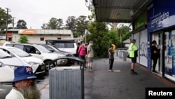 FILE - Customers queue outside a Western Sydney chemist to purchase Rapid Antigen Test kits in the wake of the coronavirus disease (COVID-19) pandemic in Sydney, Australia, Jan. 5, 2022.