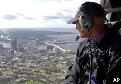 FILE - In this Sept. 12, 2017, photo, Gov. Rick Scott assesses flooding damage over Jacksonville, Fla., in the aftermath of Hurricane Irma.