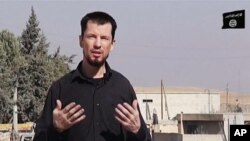 FILE - In this still image taken from an undated video published on the Internet by the Islamic State group militants, captive British journalist John Cantlie speaks into a camera in what he identifies as the Syrian town of Kobani.