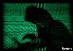 Seorang pria berkerudung sedang melakukan pembobolan dalam sebuah ilustrasi, 13 Mei 2017. (Foto: REUTERS/Kacper Pempel)