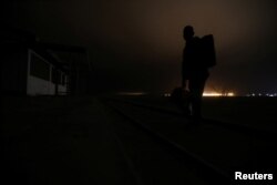 A Cuban migrant crosses the Chilean and Peruvian border following a train line to avoid frontier check points, at a mined area of desert in Arica, Chile, Nov. 15, 2018.