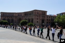 Supporters of opposition lawmaker Nikol Pashinian holds hands in Republic Square in Yerevan, May 2, 2018.