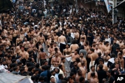 Muslim Syiah Pakistan memukul dada mereka dalam ritual menandai Ashoura, di Rawalpindi, Pakistan, Selasa, 9 Agustus 2022. Ashoura jatuh pada tanggal 10 Muharram, bulan pertama dalam kalender Islam, ketika Syiah menandai kematian Hussein, cucu Nabi Muhammad, pada Pertempuran Karbala di Irak saat ini pada abad ke-7. (AP/Anjum Naveed)