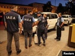 Members of International Atomic Energy Agency (IAEA) mission stand by U.N. vehicles at hotel as they depart for visit to Zaporizhzhia nuclear power plant, in central Kyiv, Ukraine, Aug. 31, 2022.