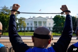 FILE - A member of the Uyghur American Association rallies in front of the White House, Oct. 1, 2020, after marching from Capitol Hill in Washington, in support of the Uyghur Forced Labor Prevention Act.