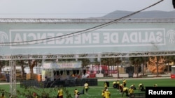 Staff members clean the venue of Medusa Festival, an electronic music festival, after high winds caused part of a stage to collapse, in Cullera, near Valencia, Spain, August 13, 2022. 