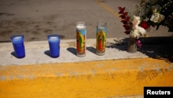 Candles and flowers are seen where unknown assailants killed employees of a radio station, including an announcer while they were outside, according to local media, in Ciudad Juarez, Mexico, Aug. 13, 2022.