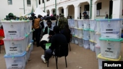 Police officers and polling staff sort sealed ballot boxes containing electoral materials at an Independent Electoral and Boundaries Commission (IEBC) tallying centre after the general election at the Jamuhuri High School in Nairobi, Aug. 10, 2022. 