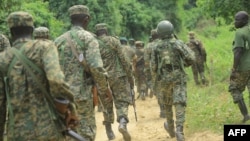 FILE - Ugandan troops are seen on a road in the Beni district of the Democratic Republic of Congo, Dec. 8, 2021. More Ugandan troops will be sent to DRC at the end of November 2022 to help fight rebels. 