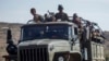 FILE - Ethiopian government soldiers ride in the back of a truck on a road near Agula, north of Mekelle, in the Tigray region of northern Ethiopia on May 8, 2021.