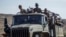 FILE - Ethiopian government soldiers ride in the back of a truck on a road near Agula, north of Mekelle, in the Tigray region of northern Ethiopia on May 8, 2021.
