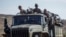 FILE - Ethiopian government soldiers ride in the back of a truck on a road near Agula, north of Mekelle, in the Tigray region of northern Ethiopia, May 8, 2021.