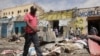 FILE - Residents look at the aftermath of an al-Shabab militant attack in Mogadishu, Aug. 21, 2022. 