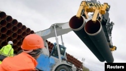 FILE - Steel pipes for the North Stream 2 pipeline are uploaded in Mukran harbour in Sassnitz, Germany.