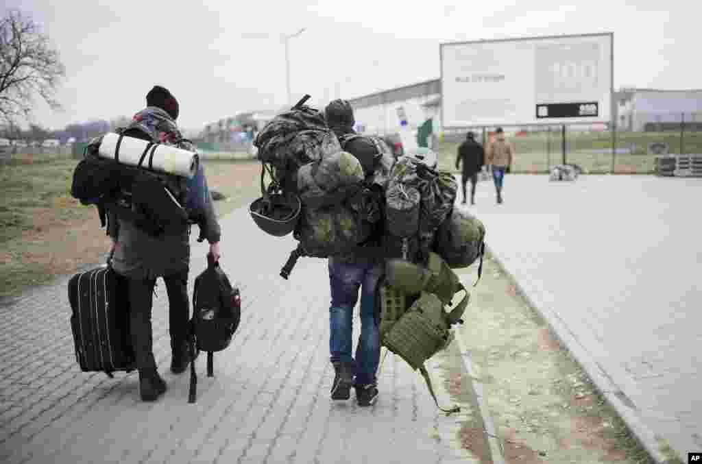 A man carries combat gear as he leaves Poland to fight in Ukraine, at the border crossing in Medyka, Poland, March 2, 2022.