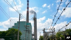 FILE—In this file photo from June 10, 2021, a flume of emissions flow from a stack at a coal-fired power plant, in Springdale, Pa.