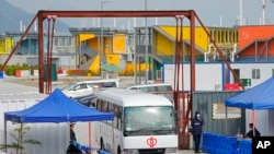 A hospital van leaves the Penny's Bay Quarantine Centre on Lantau Island, in Hong Kong, Feb. 24, 2022. Hong Kong launched a vaccination requirement to enter shopping malls, restaurants and a host of other places on Thursday.