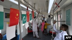 FILE - Passengers ride the Orange Line Metro Train, which was built as part of the China-Pakistan Economic Corridor investment plan, a day after its official opening in the eastern city of Lahore, Pakistan, Oct. 26, 2020.