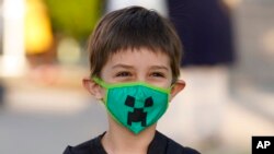 Kindergarten student Adam Shallbetter poses as his mother takes a picture after arriving at Whittier Elementary School, Aug. 24, 2021, in Salt Lake City, Utah.