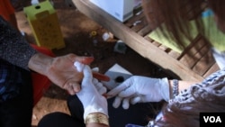 A Cambodian health agent pricks the finger of a woman who sought an HIV blood test service in Peam village, Muk Kompoul district, Kandal province, Feb 22, 2016. (Aun Chhengpor/VOA Khmer)