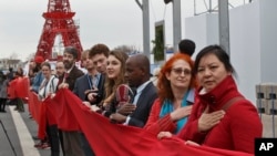 Para aktivis lingkungan menunjukkan keinginan mereka bagi tercapainya kesepakatan iklim dengan membentangkan kain warna merah di Le Bourget, hari Jumat (11/12). 