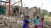 Children look at a damaged telecommunications mast after an attack by al-Shabab extremists from Somalia, in a Kenyan settlement, Jan. 13, 2020.
