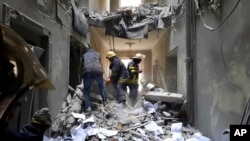 Petugas layanan darurat memeriksa kerusakan di dalam gedung Balai Kota di Kharkiv, Ukraina, Selasa, 1 Maret 2022. (Foto: via AP)