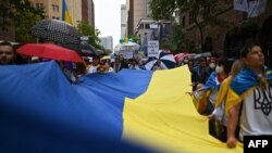 Members of the Australian-Ukrainian community carry a Ukrainian flag during a protest against Russia's invasion of Ukraine, in Sydney on Feb. 26, 2022.