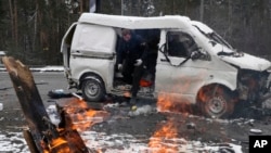 A man leaves a vehicle damaged by shelling in Brovary, outside Kyiv, Ukraine, March 1, 2022.