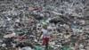 FILE - Joyce Njeri, 8, walks with a torn sack carrying the plastic bottles she has scavenged, at the garbage dump in the Dandora slum of Nairobi, Kenya.