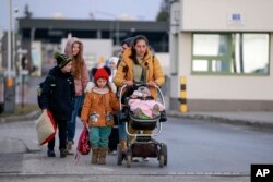 یک خانواده آواره اوکراینی در حال عبور از مرز مدیکا با لهستان. شنبه ٧ اسفند ۱۴۰۰