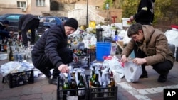 Members of civil defense prepare Molotov cocktails in a yard in Kyiv, Ukraine, Feb. 27, 2022.