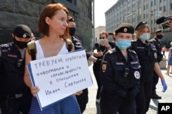 FILE - Police officers detain Yelena Chernenko, a Kommersant journalist, during a protest near the building of the Federal Security Service in Moscow, Russia, July 7, 2020.