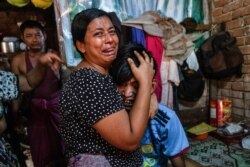 Family members cry in front of a man after he was shot dead during a crackdown on an anti-coup protesters by security forces in Yangon, Myanmar, March 27, 2021.