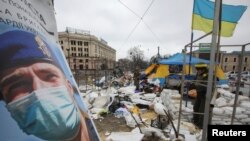 Ukrainian service members stand guard outside the regional administration building, which city officials said was hit by a missile attack, in central Kharkiv on March 1, 2022. (Vyacheslav Madiyevskyy/Reuters)